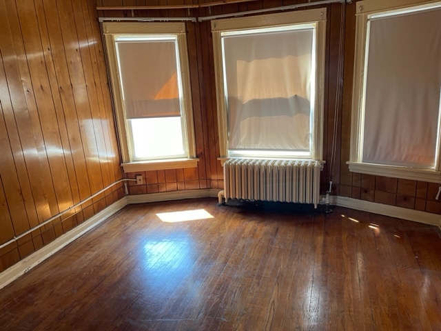 Undisclosed Address Maywood, IL 60153 - Photo 28 of 46 a view of an empty room with wooden floor and a window