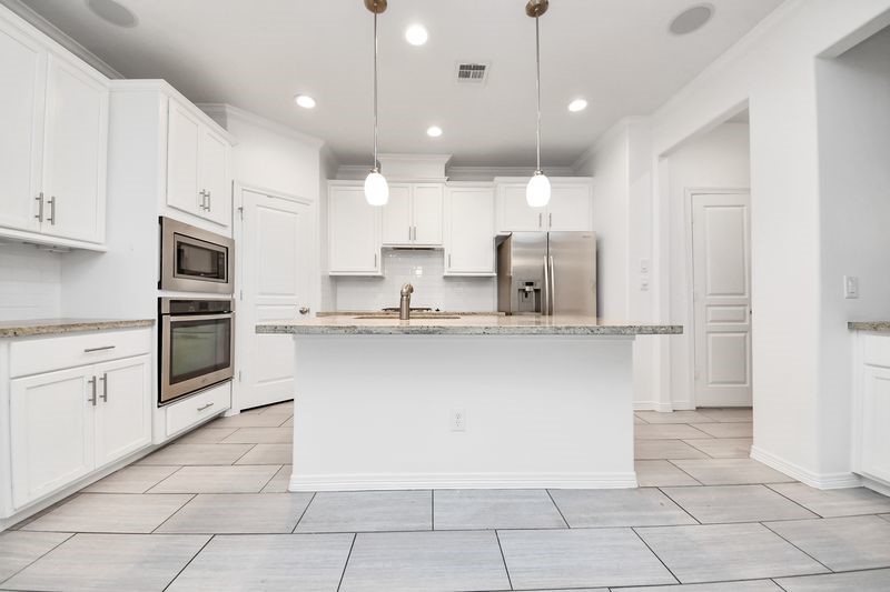4222 Drake Street Houston, TX 77005 - Photo 9 of 28 a large kitchen with cabinets and stainless steel appliances