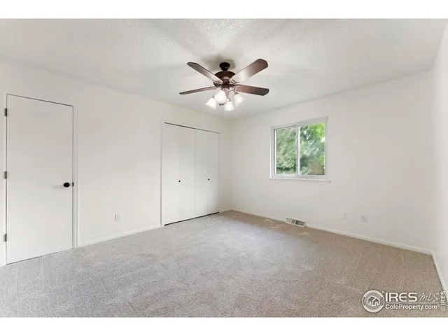 a view of an empty room with a ceiling fan