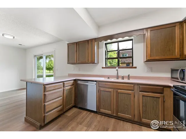 a kitchen with a sink window and cabinets