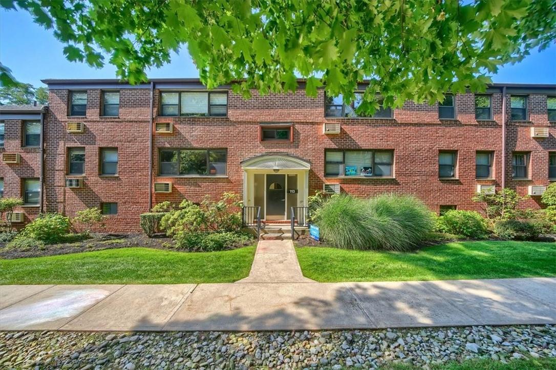 113 Beacon Hill Drive, Unit E26 Dobbs Ferry, NY 10522 - Photo 1 of 1 a front view of a house with a garden