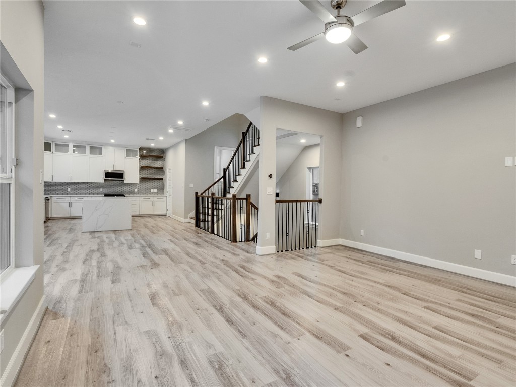 1122 West 16th Street, Unit C Houston, TX 77008 - Photo 10 of 38 a view of a big room with wooden floor a ceiling fan and windows