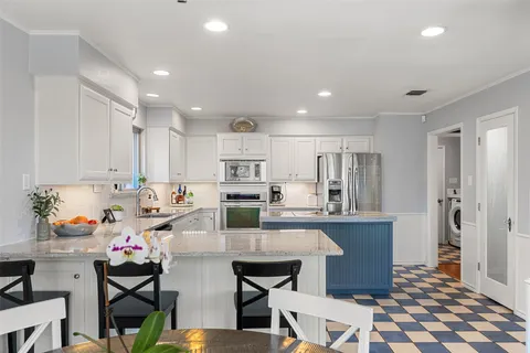 a kitchen with stainless steel appliances kitchen island granite countertop a sink and cabinets