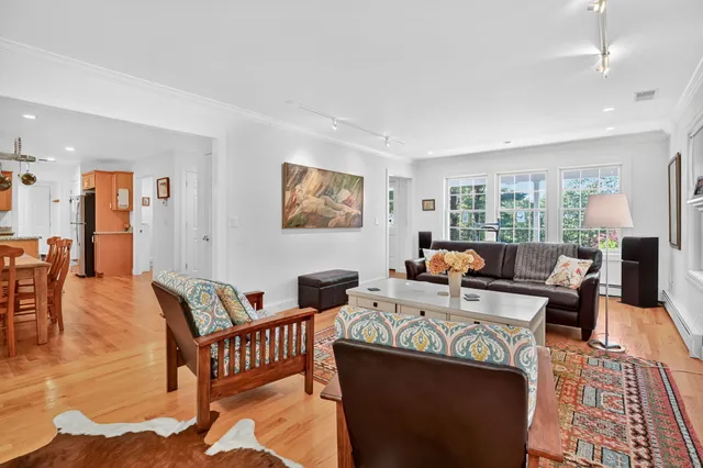a living room with furniture wooden floor and a large window