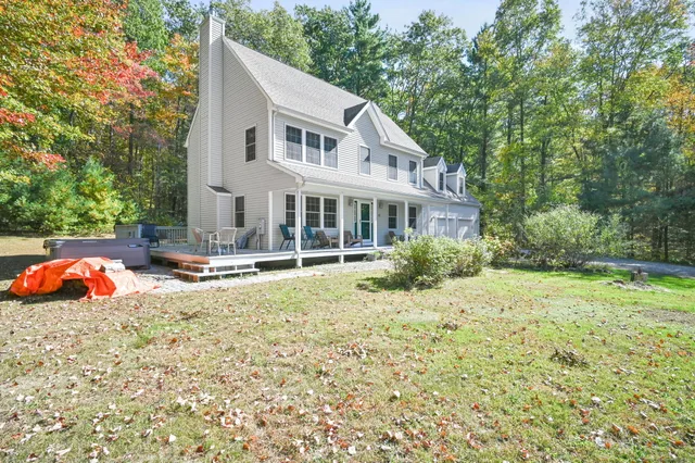 a view of a house with backyard and sitting area