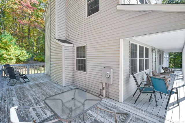 a patio with table and chairs and potted plants