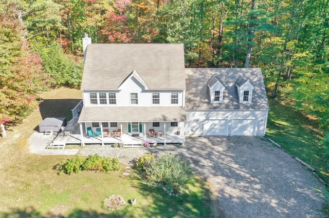 a view of a house with garden and trees in the background