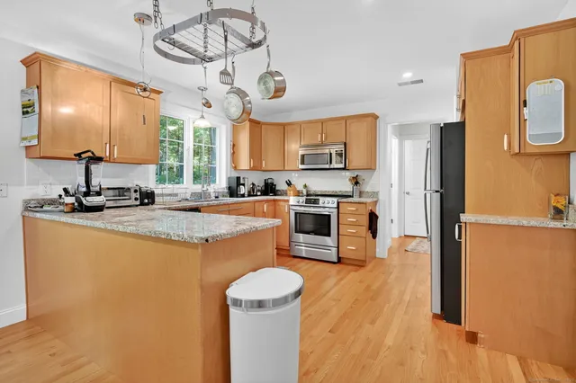 a kitchen with stainless steel appliances granite countertop a sink stove and refrigerator