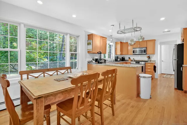 a view of a dining room and livingroom with furniture wooden floor a chandelier