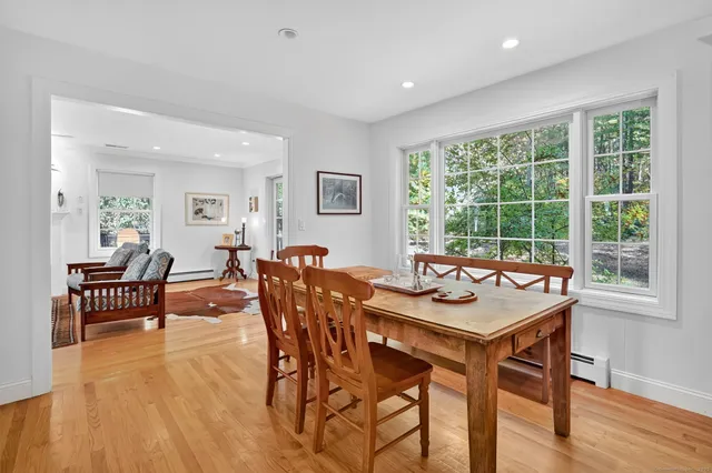 a dining room with furniture window and wooden floor