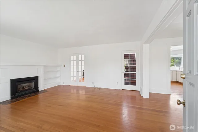 wooden floor fireplace and windows in an empty room