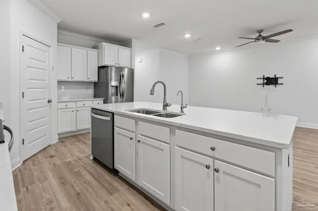 a kitchen with kitchen island white cabinets stainless steel appliances and sink