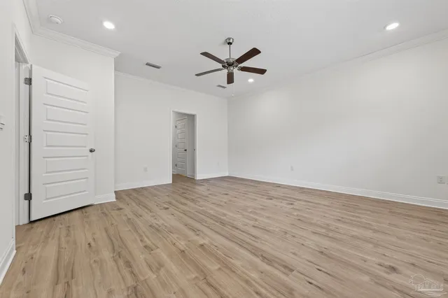 wooden floor in an empty room with a fan