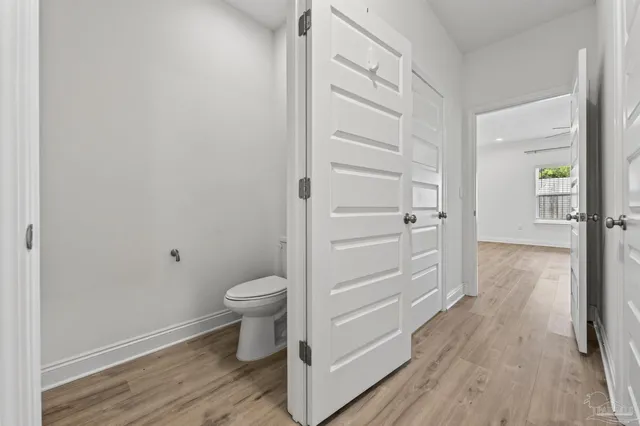 a view of a hallway with wooden floor and closet