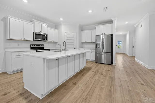 a kitchen with refrigerator a microwave oven a sink and cabinets
