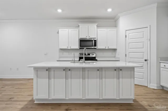 a kitchen with stainless steel appliances granite countertop a stove a sink and a microwave