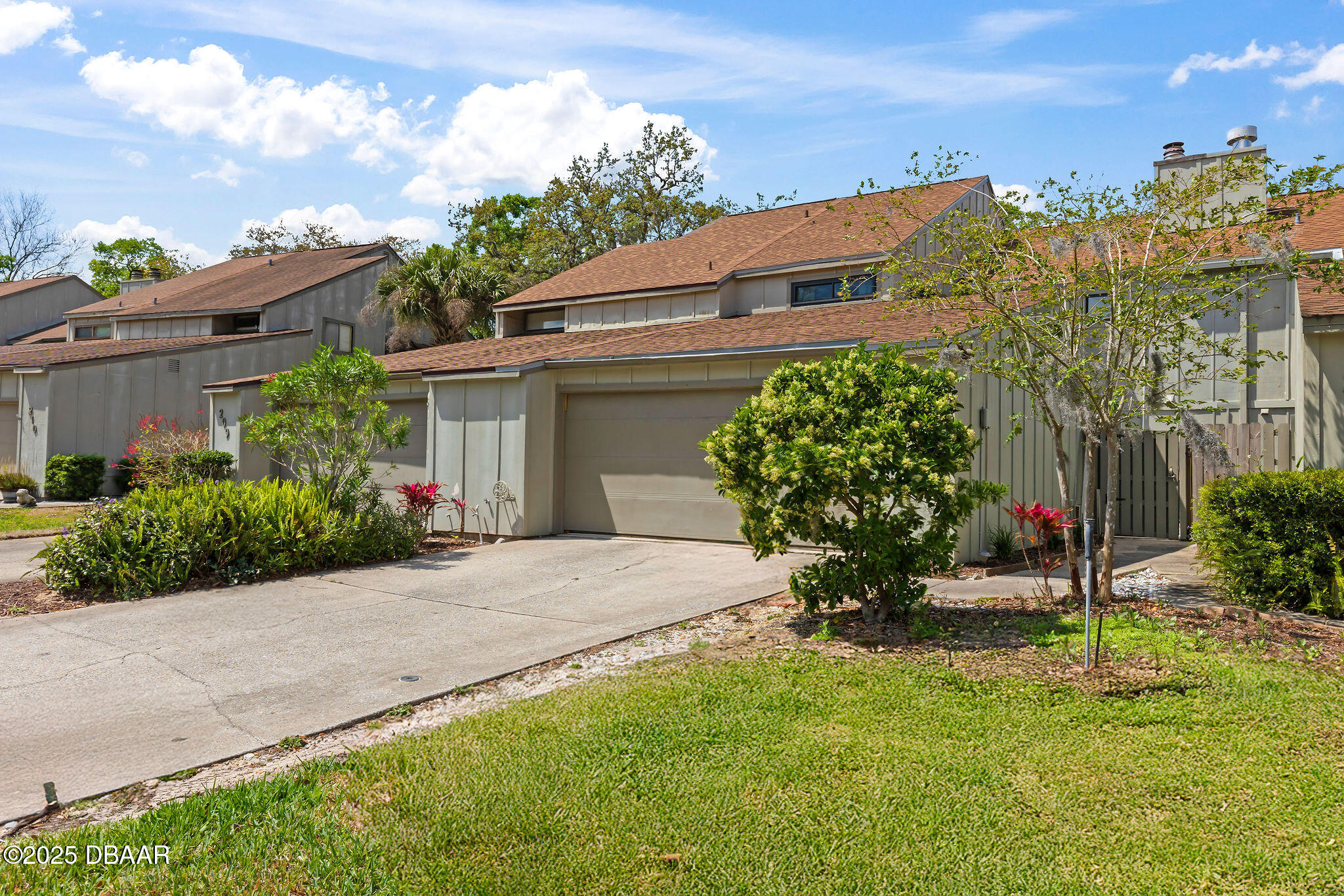 a view of a house with a yard and potted plants