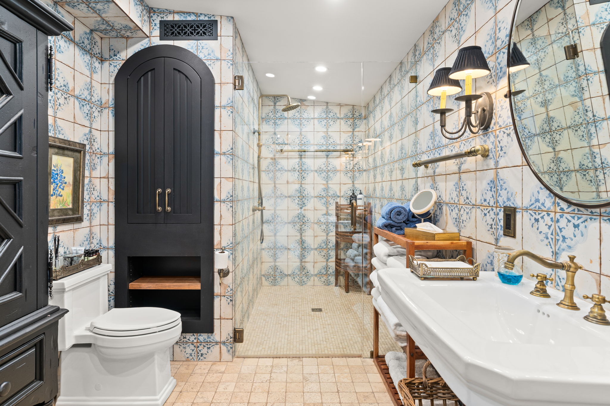 11941 Overlook Pass Austin, TX 78738 - Photo 20 of 40 Private guest bathroom featuring ornate wall tiling, a walk-in shower with glass enclosure, a pedestal sink with a brass-finish faucet, and a wall-mounted sconce