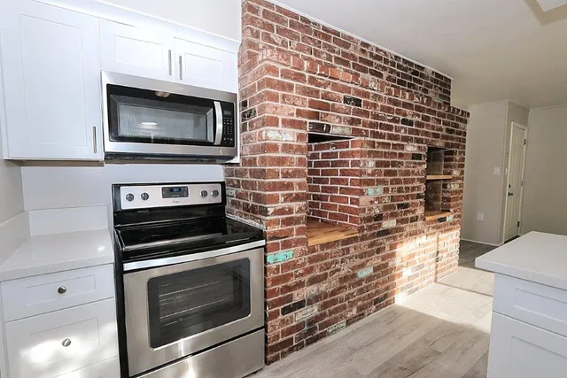 a kitchen with a sink window and cabinets