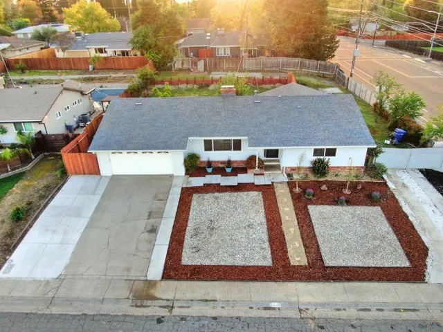 an aerial view of a house with garden space and street view