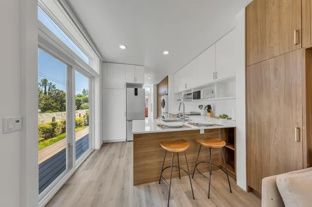 a kitchen with a sink stove cabinets and wooden floor