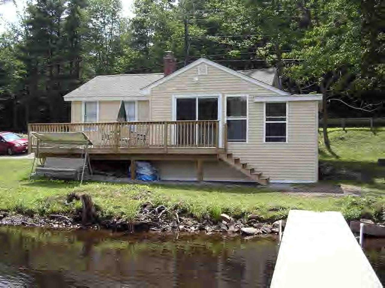 2304 North Main Road Otis, MA 01253 - Photo 1 of 8 a front view of a house with a garden and swimming pool