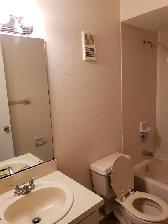 2979 Day Road, Unit C Deltona, FL 32738 - Photo 13 of 17 a bathroom with a toilet a sink and mirror