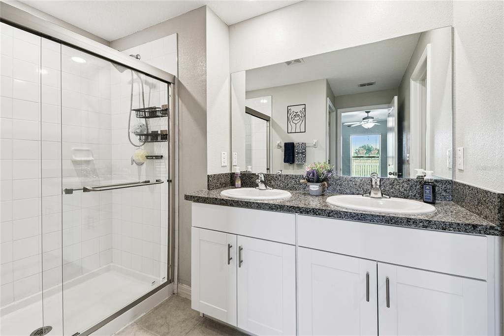 1735 Ripple Jade Place Ruskin, FL 33570 - Photo 23 of 68 a bathroom with a granite countertop sink a mirror and a shower