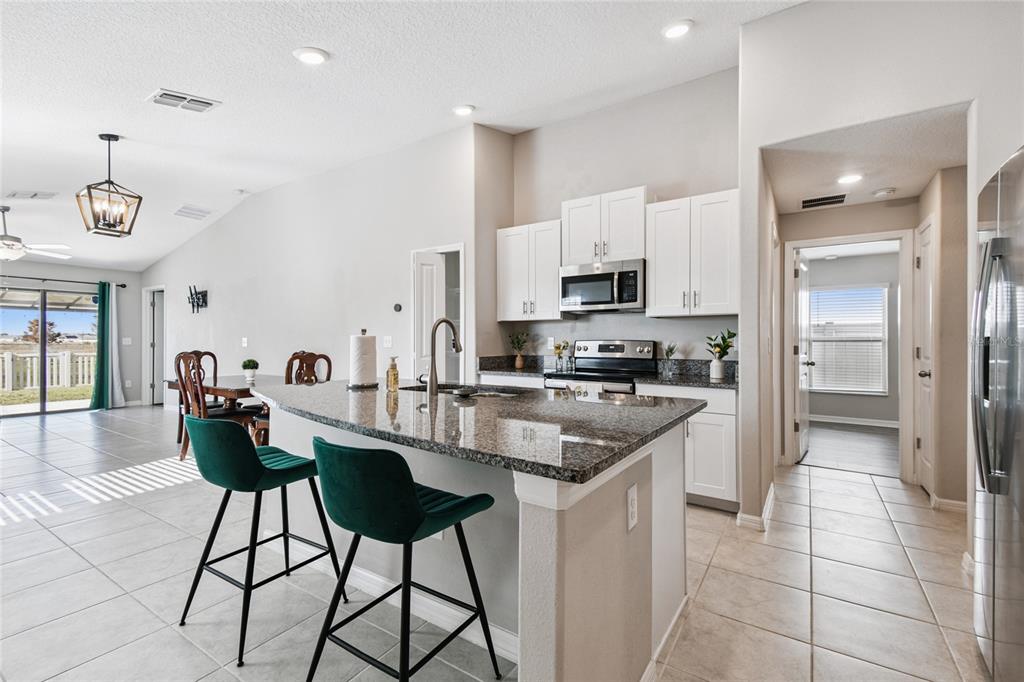 1735 Ripple Jade Place Ruskin, FL 33570 - Photo 5 of 68 a kitchen with stainless steel appliances a stove refrigerator sink and cabinets