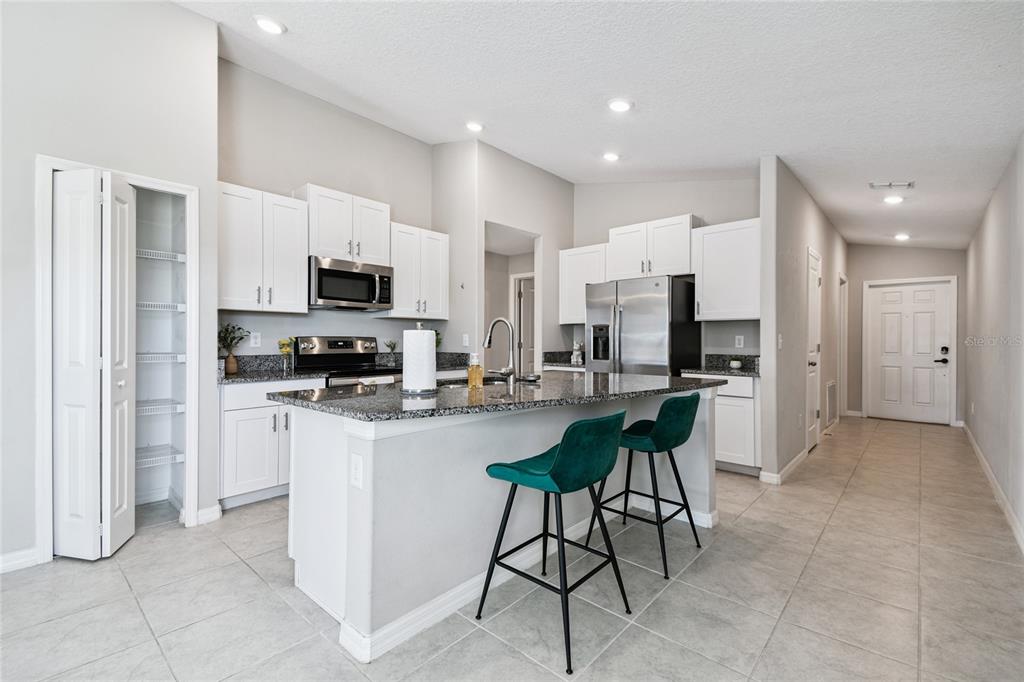 1735 Ripple Jade Place Ruskin, FL 33570 - Photo 6 of 68 a kitchen with stainless steel appliances kitchen island granite countertop a refrigerator and a stove top oven