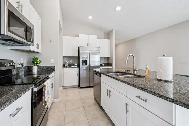 a kitchen with stainless steel appliances granite countertop a sink and stove