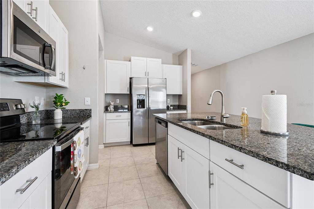 1735 Ripple Jade Place Ruskin, FL 33570 - Photo 8 of 68 a kitchen with stainless steel appliances granite countertop a sink stove and refrigerator