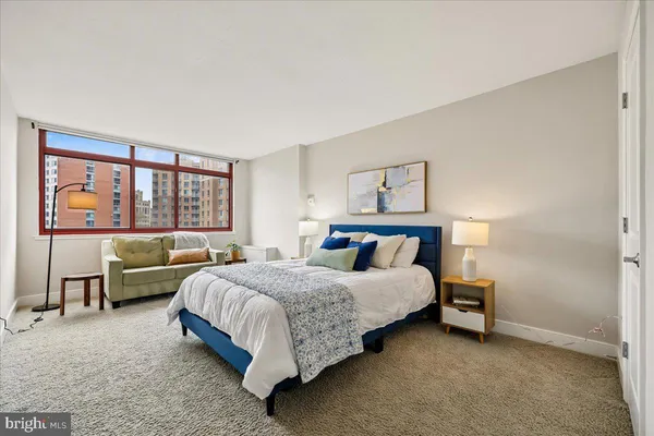 a bedroom with a bed and a large window