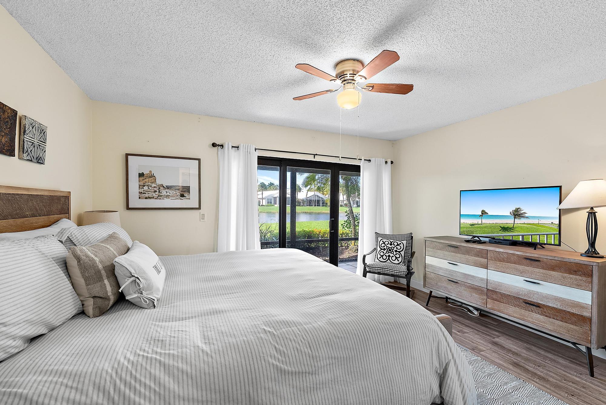 3733 Cape Pointe Circle Jupiter, FL 33477 - Photo 14 of 38 a bedroom with a bed and a chandelier