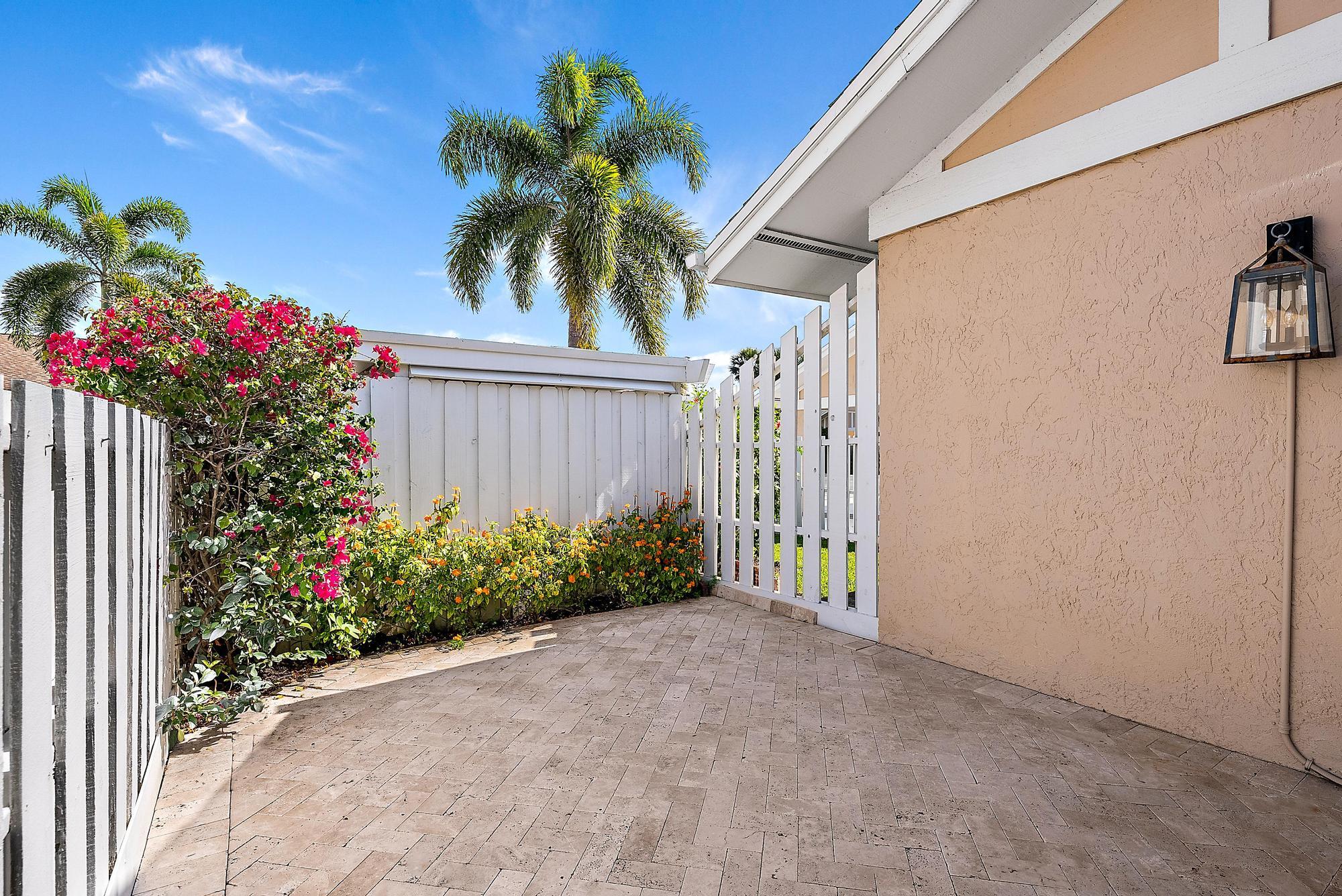 3733 Cape Pointe Circle Jupiter, FL 33477 - Photo 25 of 38 a potted plant sitting in front of a house