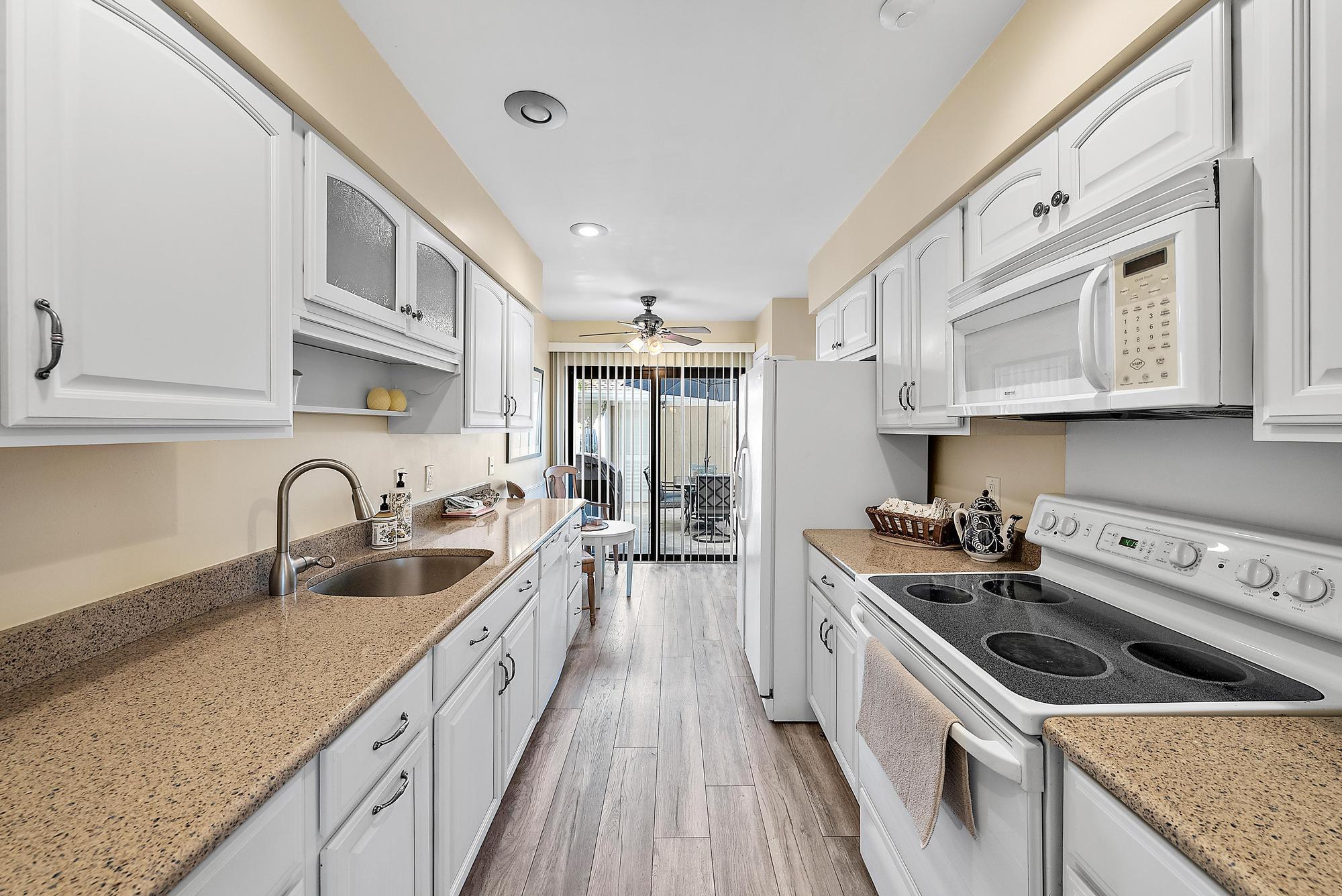 3733 Cape Pointe Circle Jupiter, FL 33477 - Photo 4 of 38 a kitchen with granite countertop a sink a stove and cabinets