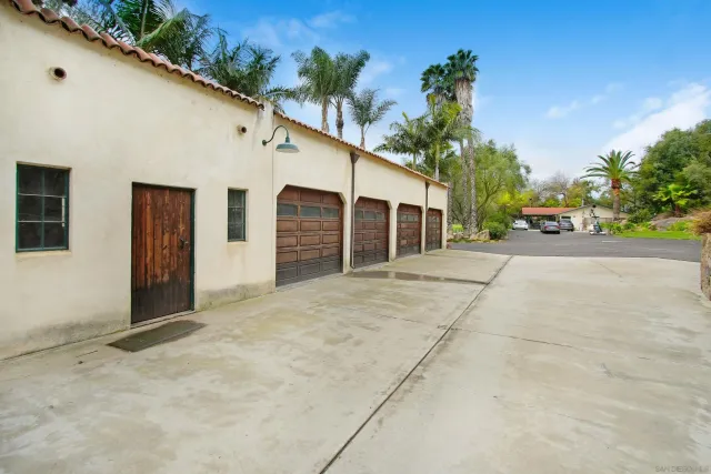 a view of a swimming pool with a yard and palm trees