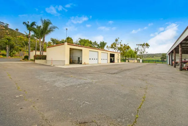 a view of a house with a yard and large trees