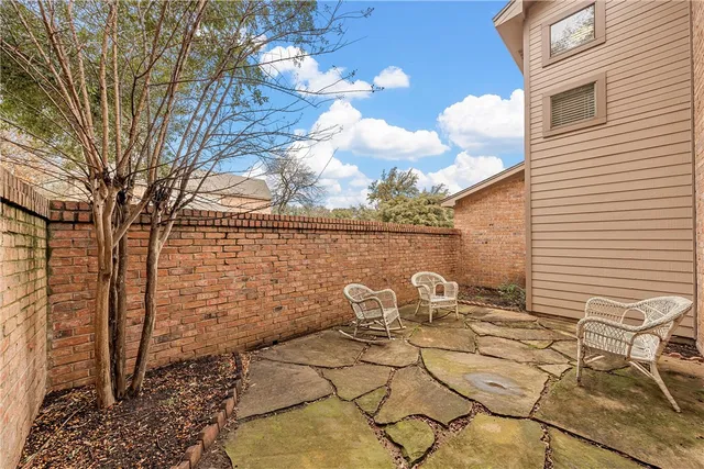 a view of a patio with chair and table and chairs and wooden fence