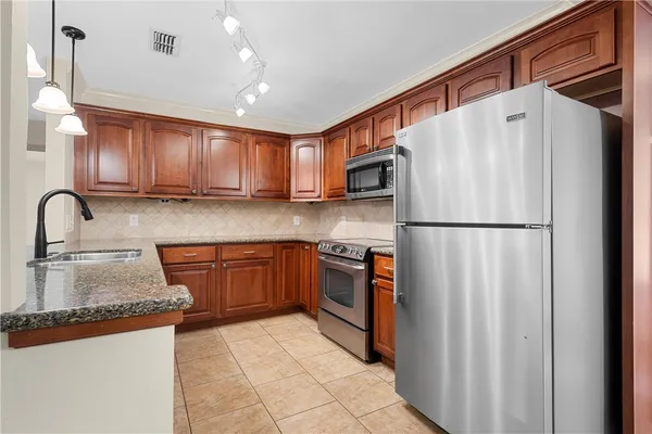 a kitchen with stainless steel appliances granite countertop a refrigerator sink and cabinets