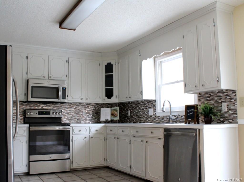 1417 Shiloh Ranch Road Lancaster, SC 29720 - Photo 8 of 23 a kitchen with stainless steel appliances granite countertop white cabinets sink and window