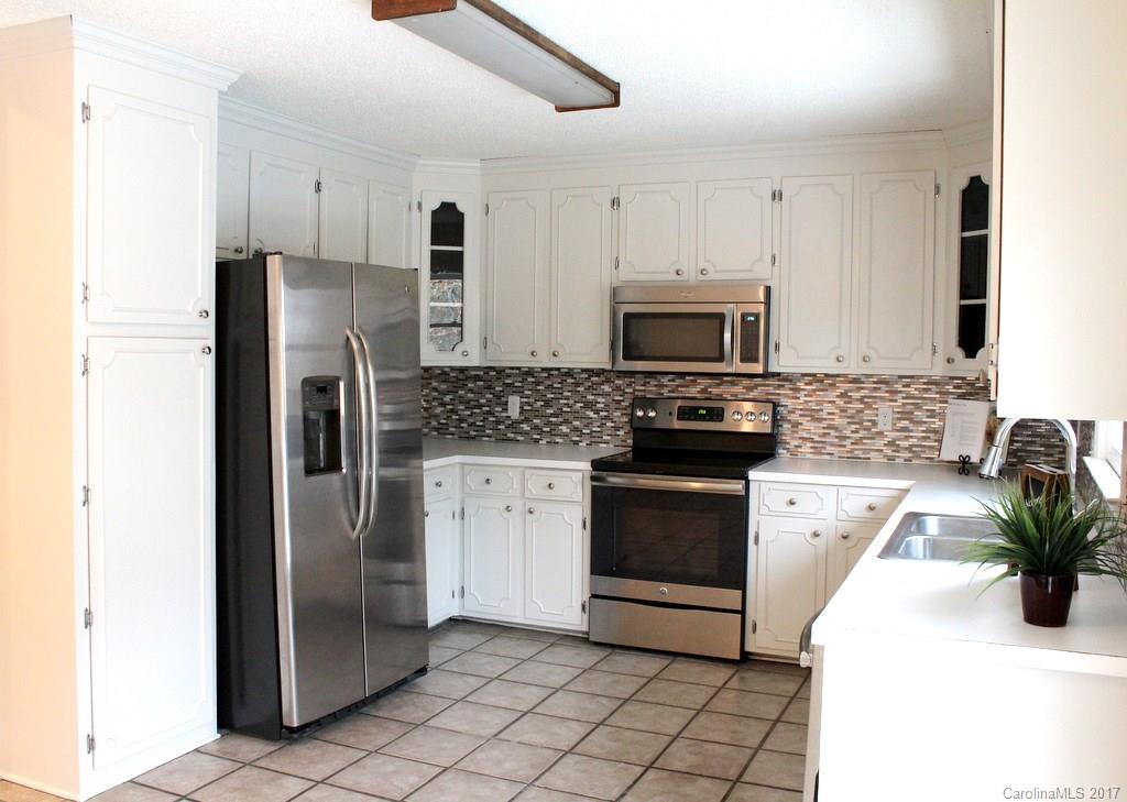 1417 Shiloh Ranch Road Lancaster, SC 29720 - Photo 9 of 23 a kitchen with a refrigerator a microwave a sink and cabinets