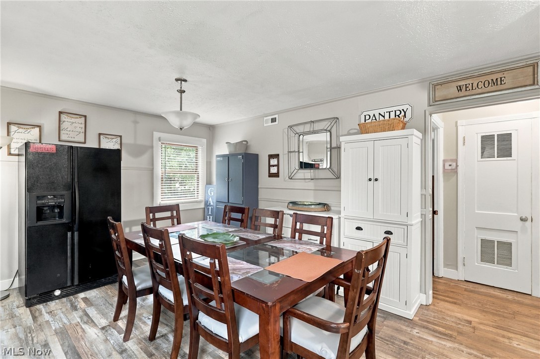 1875 Perth Road Madison, OH 44057 - Photo 33 of 48 Wood-finish flooring, white paneled door with window inserts, white built-in cabinetry, and ceiling-mounted light fixture