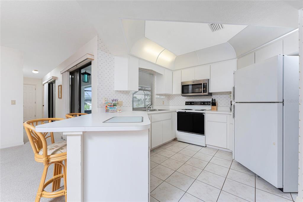21 Bunker Lane Rotonda West, FL 33947 - Photo 12 of 51 a kitchen with kitchen island white cabinets and refrigerator