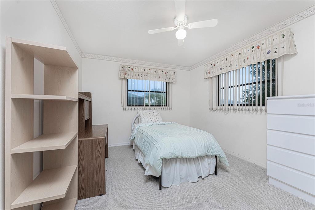 21 Bunker Lane Rotonda West, FL 33947 - Photo 22 of 51 a spacious bedroom with a bed and a chandelier