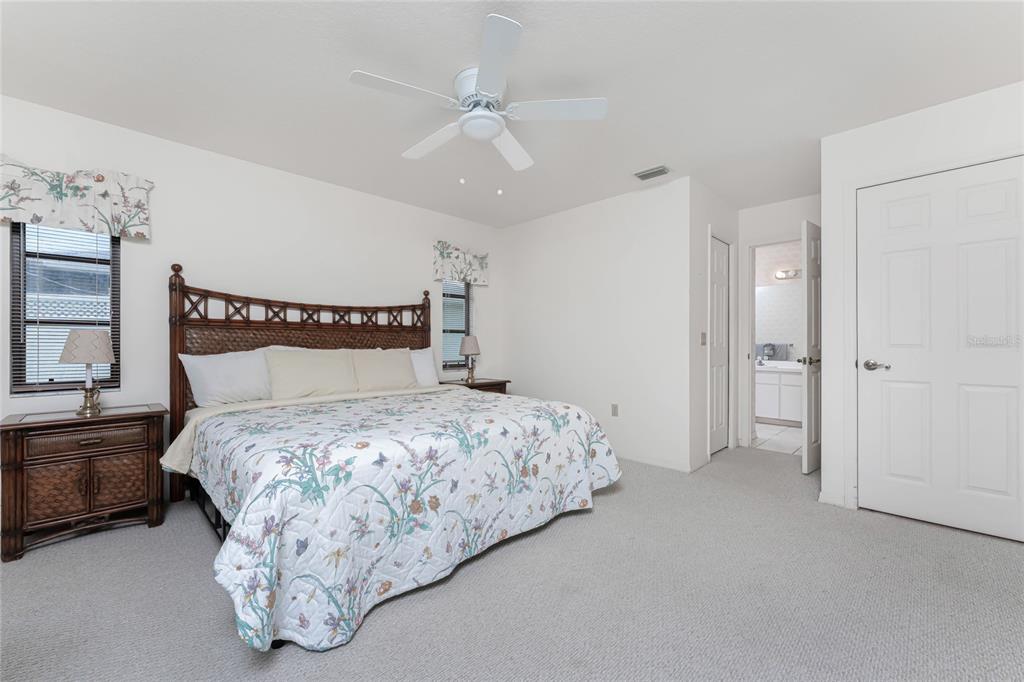 21 Bunker Lane Rotonda West, FL 33947 - Photo 34 of 51 a bedroom with a bed and a chandelier
