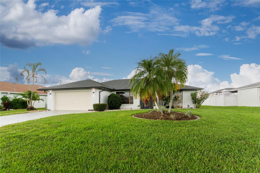 21 Bunker Lane Rotonda West, FL 33947 - Photo 50 of 51 a view of a backyard with plants and a large tree