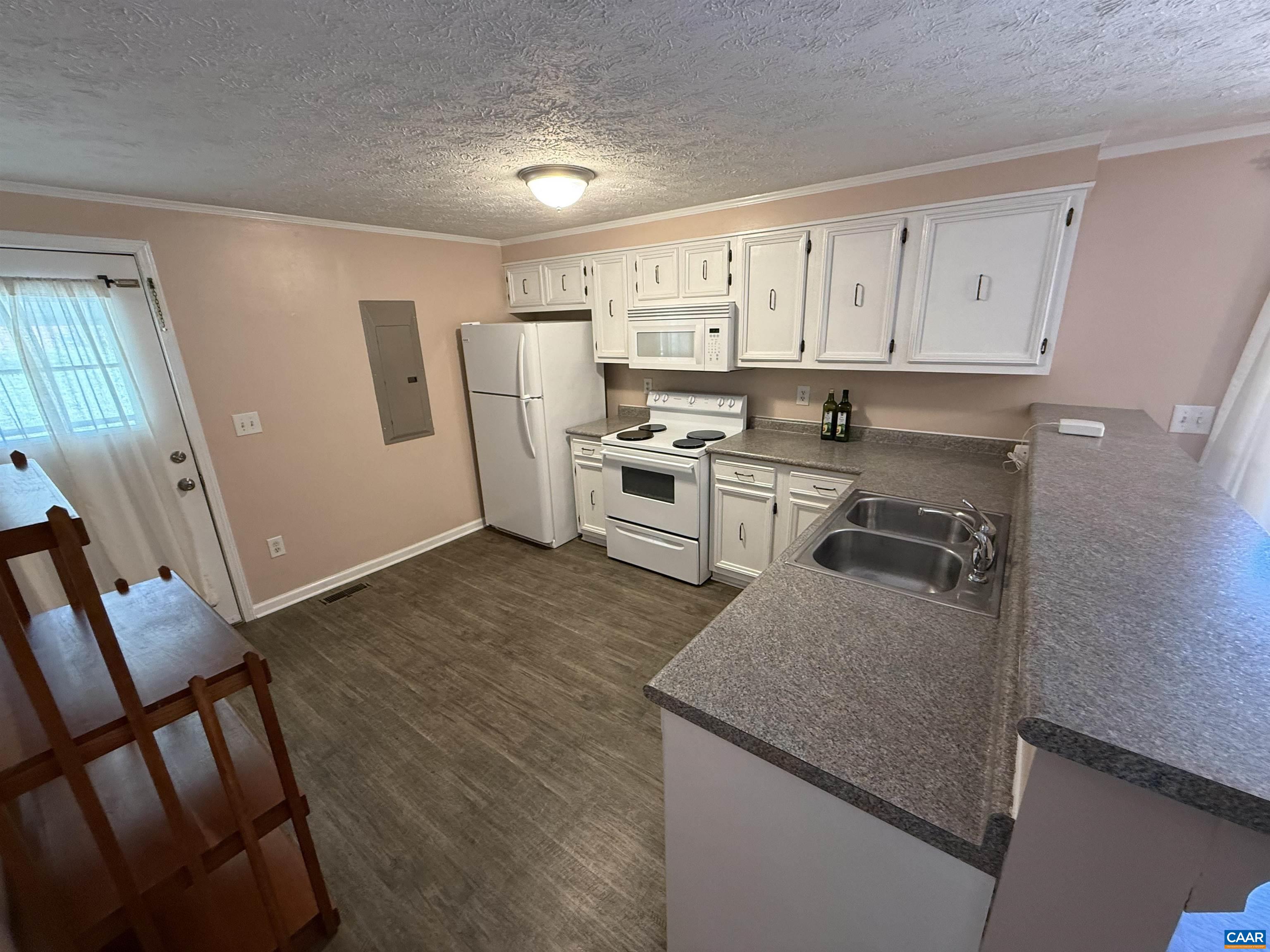 2002 Oliver Creek Road Troy, VA 22974 - Photo 6 of 38 a kitchen with white cabinets and wooden floor