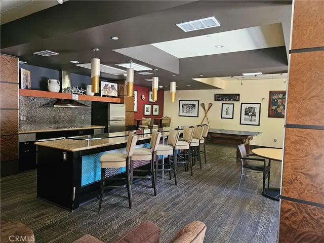 a kitchen with stainless steel appliances kitchen island granite countertop a table and chairs in it