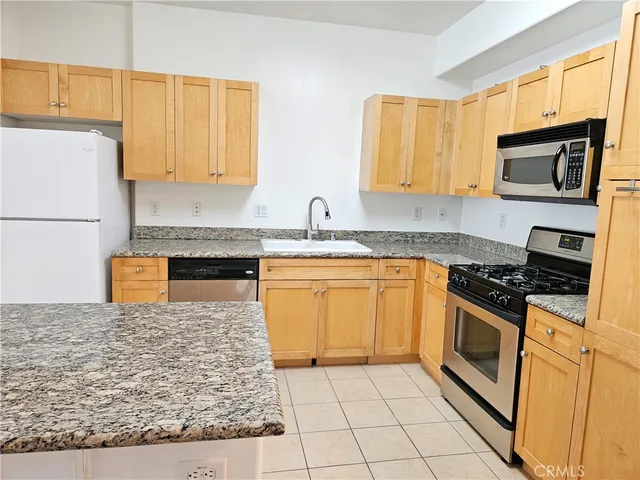 a kitchen with stainless steel appliances granite countertop a stove a sink and a microwave